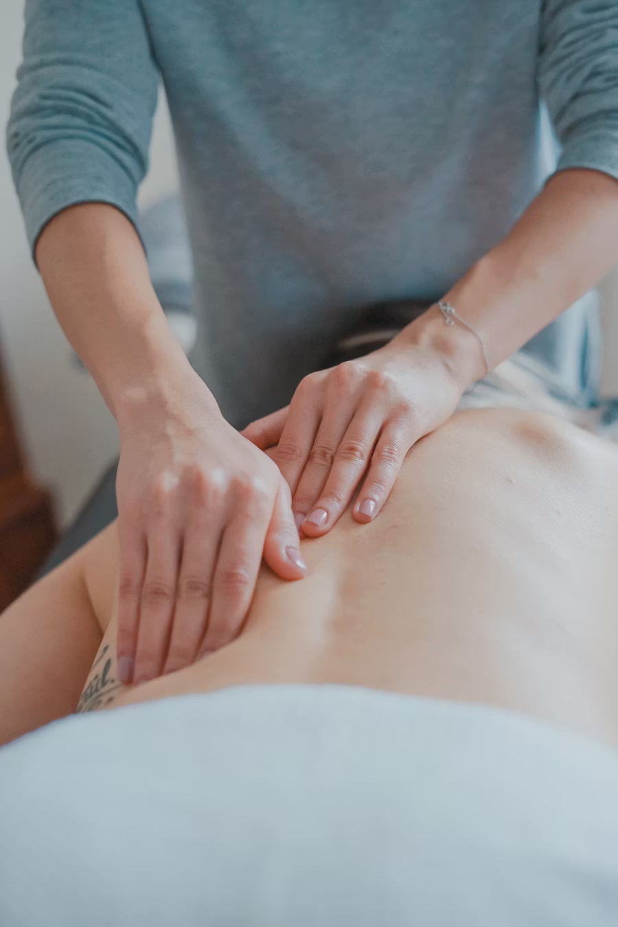Professionelle Rückenmassage zur Schmerzlinderung und Entspannung Ein Therapeut führt bei einem Klienten eine professionelle Rückenmassage durch, um Muskelverspannungen zu lösen und die Entspannung zu fördern.